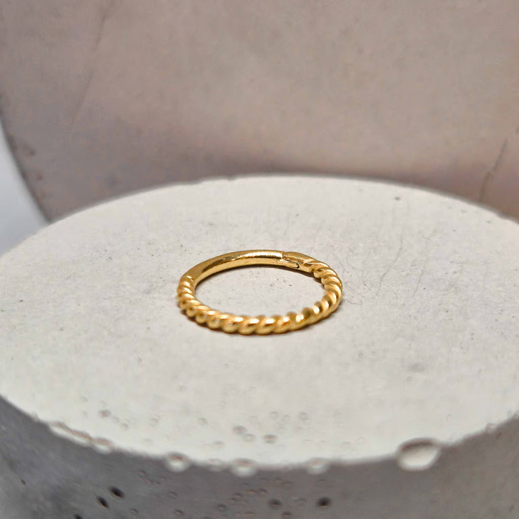 Hinged twisted segment ring gold